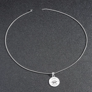 Silver stainless steel compass pendant necklace with venetian chain on black background