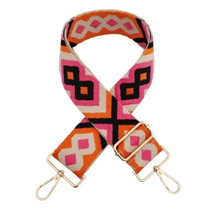 Close-up of wide embroidered jacquard bag strap with pink and orange geometric patterns