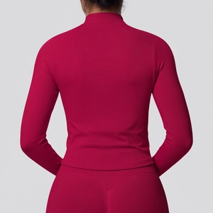 Detail of rose red athletic top with seamless ribbed texture and stand-up collar zip