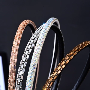 Close-up of sparkling rhinestone headbands in rose gold, silver, and amber finishes