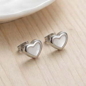 Macro di orecchini a cuore in argento con inserto in conchiglia bianca e bordo lucido