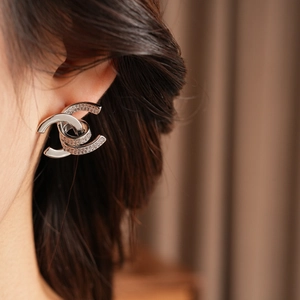 Macro shot of double-C earrings with pavé zircons worn on ear for a luxury aesthetic