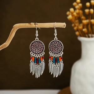 Detail of bohemian mandala earrings with colored beads and silver feather charms
