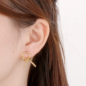 Minimalist golden geometric knot knot hollow circle stud earrings worn by a model