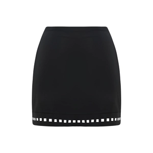 Detail of black high-waisted mini skirt featuring a geometric cutout hem design