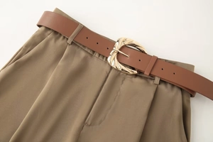 Détail du pantalon en satin avec ceinture marron assortie et boucle dorée irrégulière