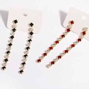 Dettaglio di orecchini pendenti in zircone con pietre a taglio quadrato in rosso e nero