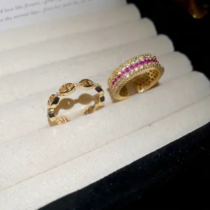 Squisiti anelli cavi placcati oro 18k con zirconia rosa e bianca su vassoio velluto