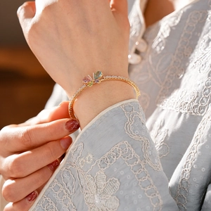 Eleganter goldener Schmetterlings-Armreif mit bunten Zirkonsteinen und Kristallen am Handgelenk