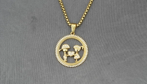 Macro detail of gold boy and girl pendant with sparkling pavé crystals and square link chain