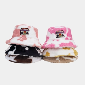 Faux fur bucket hat with retro cassette patch and stylish cow print for winter warmth