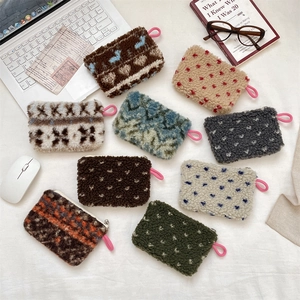 Detailed display of nine colorful plush sherpa fleece mini pouches on a desk setup