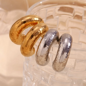 Hammered C-shaped hoop earrings in 18K gold and silver finish on glass texture
