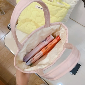 Pink quilted floral handbag with spacious interior holding two books for daily use