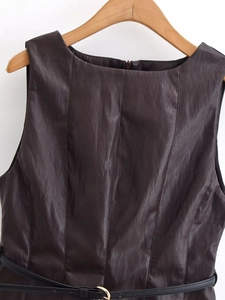 Détail du haut sans manches en similicuir avec ceinture montrant coutures et texture