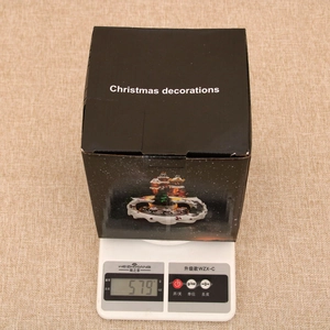 Detailed view of boxed Christmas gingerbread train decor on a digital scale weighing 579g