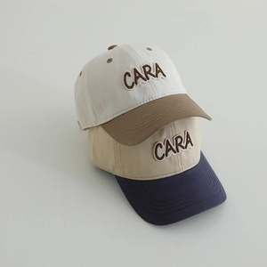 Detail of CARA letter embroidery on color-block cotton baseball caps for kids