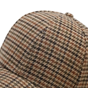 Close-up of brown houndstooth baseball cap showing fabric texture and neat stitching