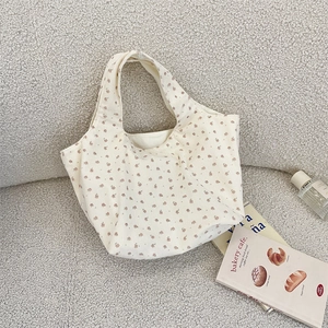 Close-up of corduroy floral tote bag texture with aesthetic background props