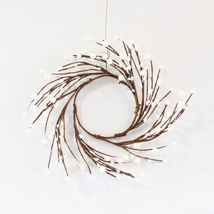 Detail of a handmade rustic wreath featuring realistic white berries on brown wood branches