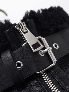 Detailed close-up of high-quality faux leather texture and silver buckle on black fleece jacket
