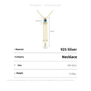 Detail showing the 925 silver gold-plated necklace with a blue pear-shaped gemstone pendant