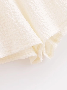 Close-up of white waffle texture fabric showing soft cotton linen material details
