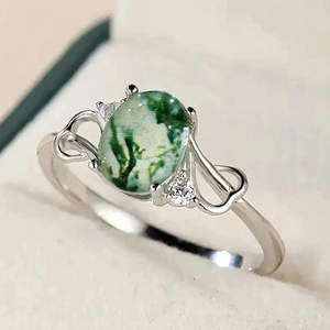 Macro shot of vintage silver ring featuring oval moss agate and side zircons