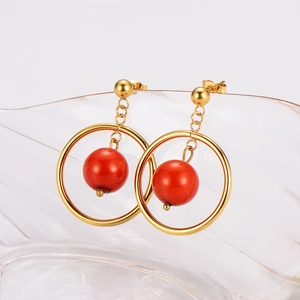 Vintage stainless steel hoop earrings with elegant red bead pendants on glass stand