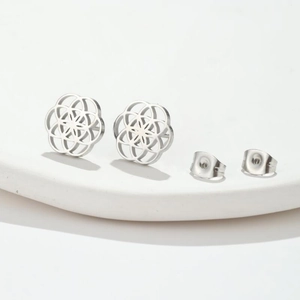 Macro view of geometric hollow flower stud earrings with butterfly backings