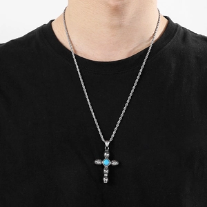 Detailed view of a silver Cross Vajra pendant with turquoise bead on a twist chain