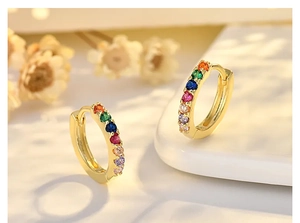 Macro shot of rose gold hoop earrings with multi-color cubic zirconia rainbow stones