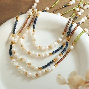 Bohemian multilayer necklace with freshwater pearls and colorful glass beads on ceramic