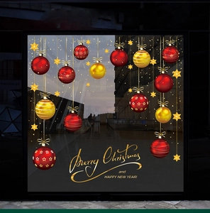 Window display with red and gold Christmas ball ornaments and festive star stickers