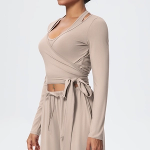 Detail view of khaki yoga set featuring V-neck crossover tie-waist top and wide-leg pants