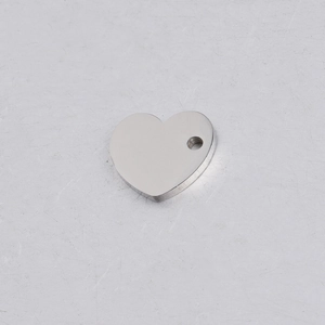 Detail van gepolijste zilveren hartvormige hanger met ophanggat voor DIY sieraden maken