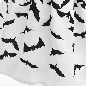 Close-up of white Halloween dress fabric featuring black bat silhouettes and soft texture