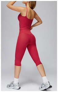 Detail of red high-waist yoga leggings with lift design and matching cropped tank top