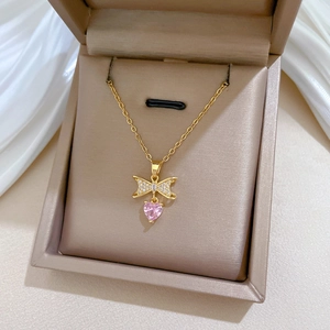 Golden bow necklace with pink heart pendant and cubic zirconia in a jewelry box