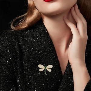 Exquisite dragonfly brooch detail featuring sparkling rhinestones and green crystal accents.