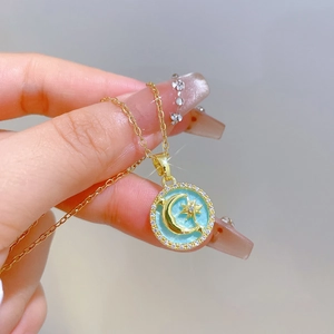 Elegant gold celestial necklace featuring a blue moon and star pendant with crystals