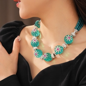 Close-up of vintage floral necklace with turquoise pumpkin beads and rhinestone accents