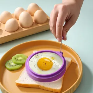 Macro shot of purple silicone fried egg mold with handle on toast with colorful plates