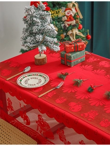 Detail of red Christmas lace tablecloth with Santa Claus and festive bell patterns