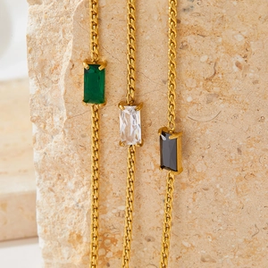 Three gold Cuban chain bracelets with green, white, and black rectangular crystal pendants
