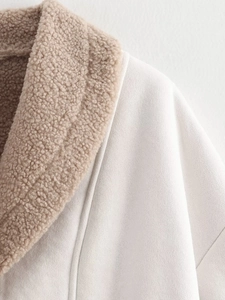 Detail view of cozy beige faux shearling collar and textured suede fabric on winter jacket