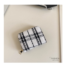 Detailed macro of black and white tweed lady's purse with golden metallic zipper slider
