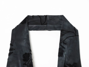 Dettaglio del tessuto a rete nero con elegante motivo a rose e trama in velluto