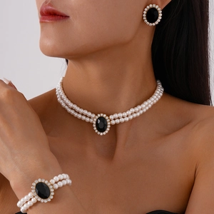 Three-piece luxury pearl jewelry set with black oval gemstone and diamond accents