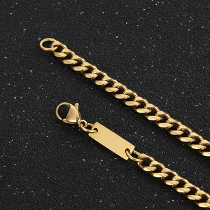 Close-up of golden Cuban link chain with lobster clasp and rectangular blank tag